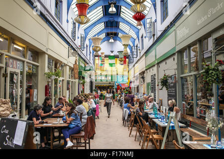 Brixton Village market, Londra, Regno Unito. Persone gustare del cibo e delle bevande nel villaggio di Brixton, Brixton iconici mercato coperto. Foto Stock