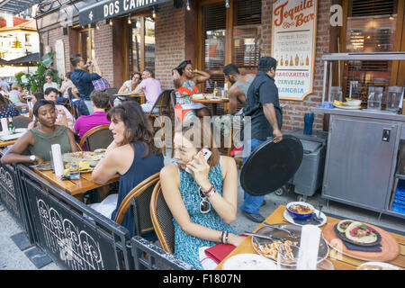 Diverse multirazziale folla di giovani godendo il pranzo al di fuori al Dos Caminos ristorante nel trendy Quartiere Meatpacking Foto Stock