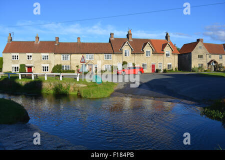 Marr la Beck fluisce attraverso il villaggio di Hovingham in Ryedale quartiere di North Yorkshire, Inghilterra. Foto Stock