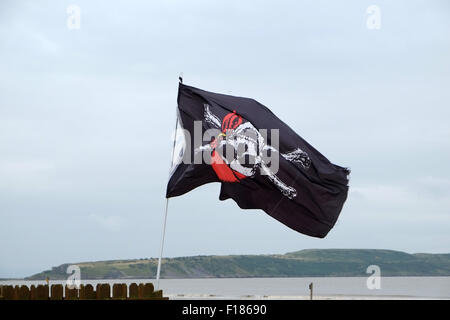 Capovolto pirata battenti bandiera sulla spiaggia di Weston super Mare Foto Stock