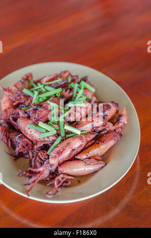 Piastra del saltata di piccoli calamari fritti con aglio e salsa Foto Stock