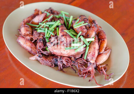 Piastra del saltata di piccoli calamari fritti con aglio e salsa Foto Stock