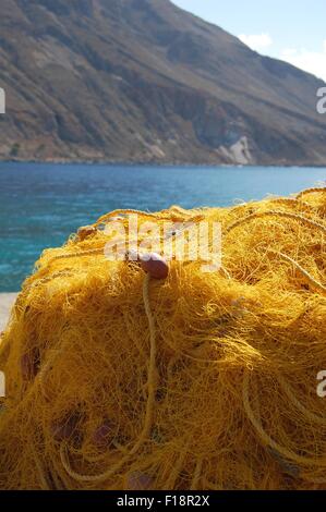 Il giallo delle reti da pesca sulla riva a Loutro Creta Grecia Foto Stock