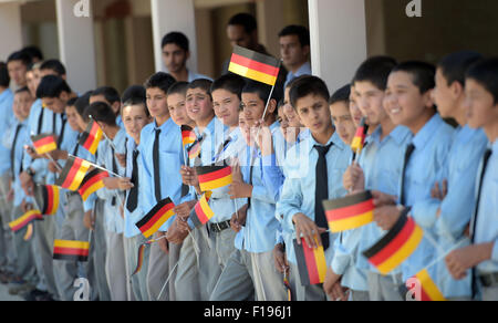 A Kabul, Afghanistan. Il 30 agosto, 2015. Il Ministro degli esteri tedesco Frank-Walter Steinmeier (non raffigurato, SPD) è accolto da alunni sventolando bandiere tedesca al Amani high school a Kabul, Afghanistan, 30 agosto 2015. Steinmeier è su una due giorni di visita alla regione. Foto: RAINER JENSEN/DPA/Alamy Live News Foto Stock