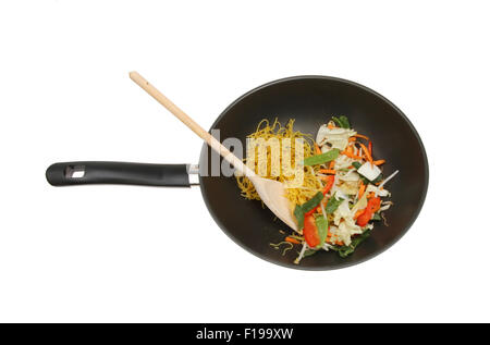 Friggere ingredienti, verdure e tagliatelle in un wok isolata contro bianco Foto Stock