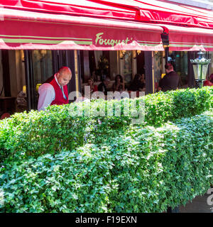 Cameriere serve patroni al famoso ristorante Le Fouquet's sulla Avenue des Champs Elysees di Parigi Foto Stock