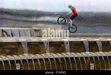 Stunt ciclista al bordo di taglio della scultura in acciaio e funzione acqua a Sheffield stazione ferroviaria Foto Stock