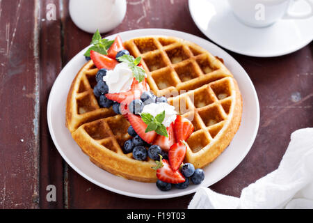 Waffles Freschi Fatti in casa con ripieno di ricotta servito con panna montata e frutti di bosco Foto Stock