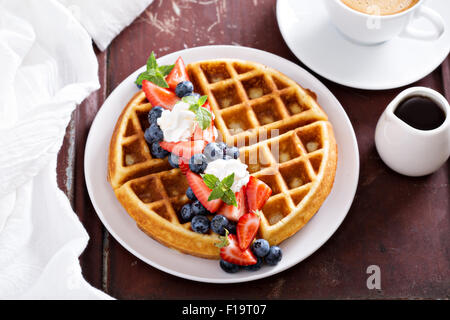 Waffles Freschi Fatti in casa con ripieno di ricotta servito con panna montata e frutti di bosco Foto Stock