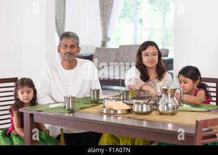 Famiglia indiana a pranzare in casa. Foto di India persone mangiare riso sul tavolo da pranzo. Casa Tradizionale cucinare pasti. Foto Stock