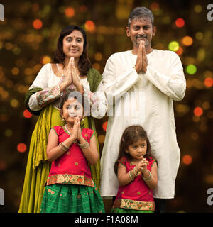 Famiglia indiana saluto il Diwali, la festa delle luci, all'interno di un tempio. Foto Stock