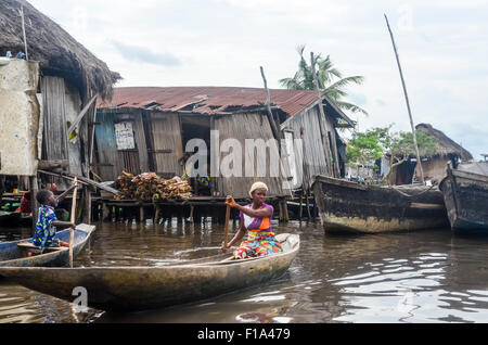 Signora su una piroga Ganvié, 'Venezia d'Africa", villaggio di palafitte sul lago vicino a Cotonou in Benin Foto Stock