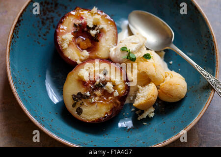 Pesche al forno con timo, gelati e amaretti Foto Stock