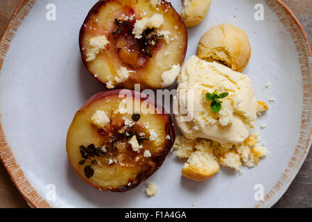 Pesche al forno con timo, gelati e amaretti Foto Stock