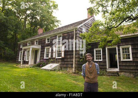 Old Bethpage, New York, Stati Uniti d'America. Il 30 agosto, 2015. Matt, un personale stagionale stati indossando il tradizionale stile di abbigliamento americano, si trova nella parte anteriore del Powell House alla fine di un tour durante il vecchio tempo musica Weekend al vecchio villaggio di Bethpage restauro. La casa è stata costruita nel 1750 e viene ripristinato alla sua espanso formato 1855, ed è il solo edificio permanente sulla sua posizione originale nel villaggio. Credito: Ann Parry/ZUMA filo/Alamy Live News Foto Stock