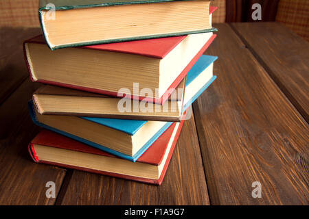 Pila di libri antichi su legno rustico sfondo con spazio di copia Foto Stock