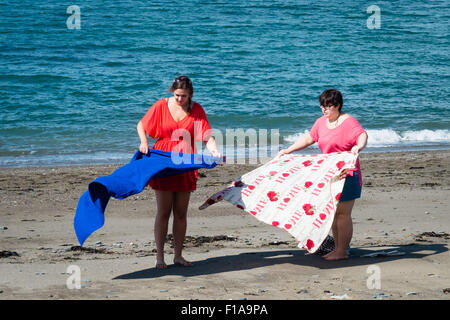 Aberystwyth, Wales, Regno Unito. Il 31 agosto, 2015. Regno Unito Meteo : Due donne posa asciugamani sulla spiaggia godendosi il sole su una ventilata ma calda e soleggiata lunedì festivo al mare in Aberystwyth, sulla West Wales coast UK Photo credit: Keith Morris / Alamy Live News Foto Stock