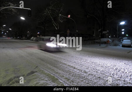 Berlino, Germania, auto guidare di notte su una strada innevata Foto Stock