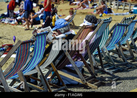 I vacanzieri seduti in sedie a sdraio. Southend-on-Sea. Essex. Regno Unito Foto Stock