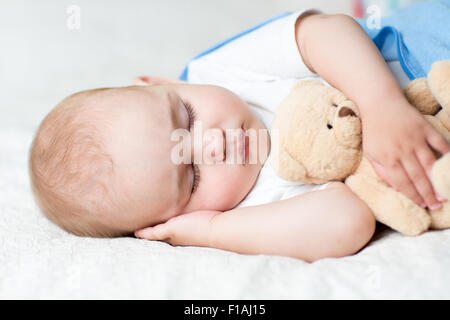 Spensierato dormire bambino con il giocattolo morbido Foto Stock