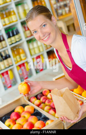 Supermercato lavoratore nella sezione di frutta Foto Stock