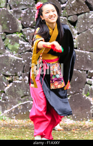 Kumamoto, Giappone, Yosakoi Festival. Corpo di ballo di bambini, 10-16 anni, tenendo naruko e in nero happi coats, ballare nella parte anteriore del muro di castello. Foto Stock