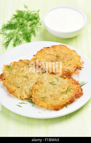 Patate fritte frittelle, panna acida e aneto Foto Stock