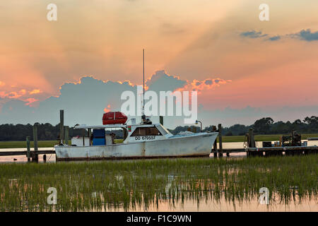 Un granchio barca legato alla Crosby il dock al tramonto in follia Beach, SC. Foto Stock
