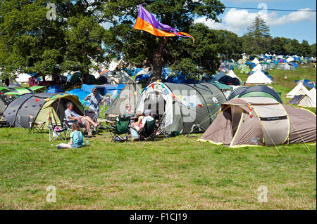 Persone sedute in sedie da campeggio al di fuori delle loro tende al campeggio al porto Eliot festival Cornwall Regno Unito Foto Stock