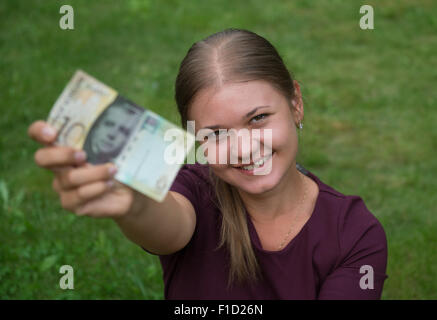 Felice giovane donna bionda azienda Swiss franc banconota Foto Stock