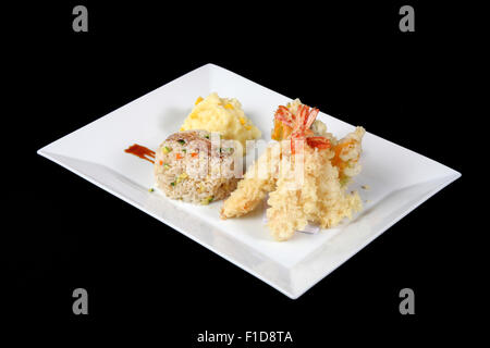 Menu di pesce fritto con riso e purè di patate nel piatto bianco, su blac Foto Stock