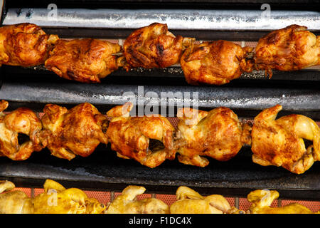 Pollo arrosto in una fila girando alla torrefazione industriale Foto Stock