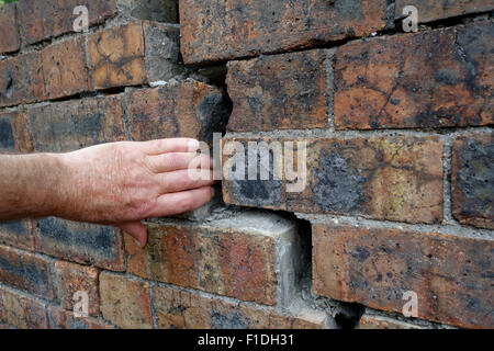 Il vecchio muro di mattoni della subsidenza crack crepe abbassandosi pareti Foto Stock
