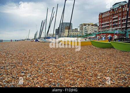 Barche colorate in attesa di andare di nuovo a vela sulla spiaggia rocciosa a Brighton, Inghilterra Foto Stock