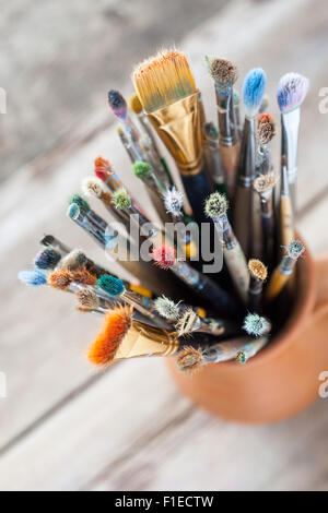Usato pittore pennelli in una brocca da potters argilla. Vista dall'alto. Foto Stock