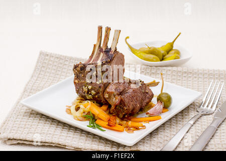 Grigliata di carré di agnello con cipolla carota, aglio e rosmarino Foto Stock