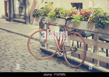 Bicicletta sulla vecchia strada. vintage stilizzato. Foto Stock