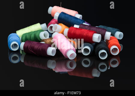 Bobine con multi-colore di fili di cucitura su sfondo nero Foto Stock