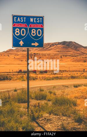 American Interstate I-80 in Stato di Nevada. Interstate entrata segno e alcuni semi velocizzando il carrello. Foto Stock