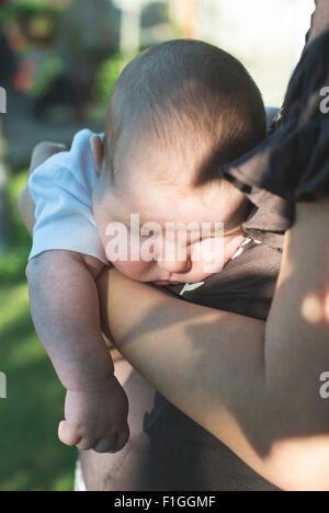 Bambino in braccio a sua madre. Close up Foto Stock