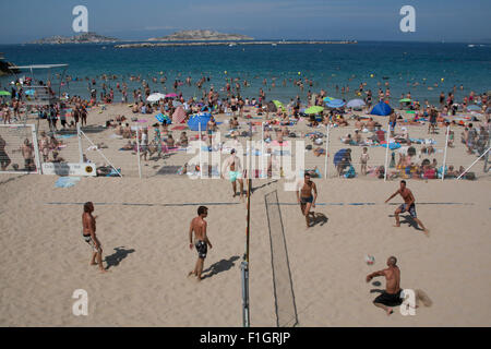 Persone a giocare a pallavolo sulla trafficata catalani o spiaggia Plage des Catalans nei pressi della città di Marsiglia, Francia Foto Stock