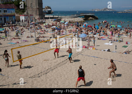 Persone a giocare a pallavolo sulla trafficata catalani o spiaggia Plage des Catalans nei pressi della città di Marsiglia, Francia Foto Stock