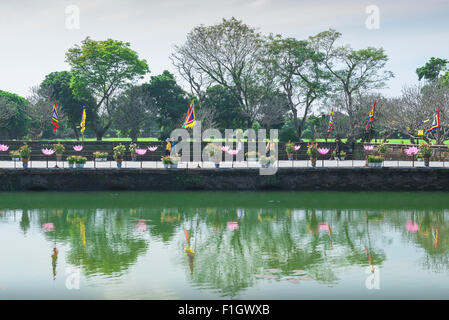 Hue Vietnam cittadella, turisti camminare al fianco di uno dei tanti laghi all'interno della cittadella imperiale di Hue, Vietnam centrale. Foto Stock
