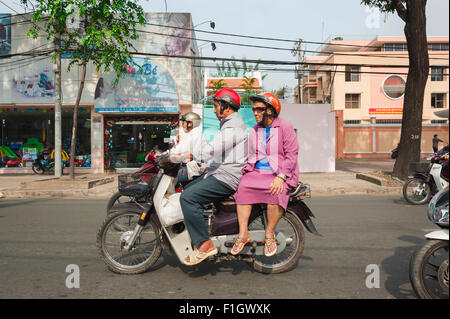 Motocicletta di persone anziane, una coppia di anziani velocità attraverso il traffico di punta-ora su una moto a Tran Hung Dao a ho Chi Minh City, Saigon, Vietnam Foto Stock