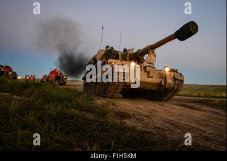Questa immagine cattura il 1st Battalion dello Yorkshire Regiment impegnato in esercitazioni di tiro dal vivo durante l'esercitazione Prairie Lightning, mostrando l'uso del cannone semovente AS-90 e dei veicoli corazzati come il vettore personale FV510. Foto Stock