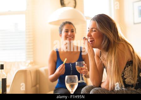 Due giovani donna avente le ragazze di notte, bere e ridere Foto Stock