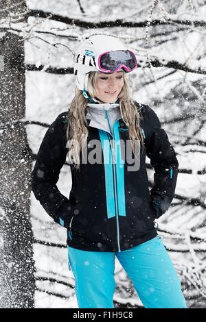 Metà donna adulta indossando skiwear in snow, ritratto Foto Stock