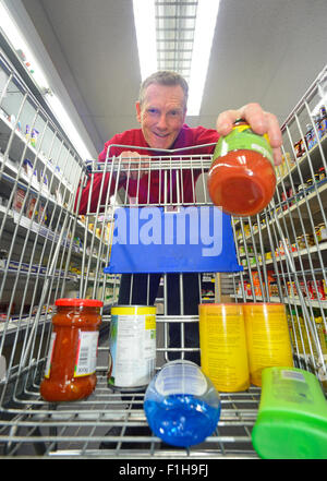 L'uomo carrello utilizzando il carrello in un supermercato Foto Stock