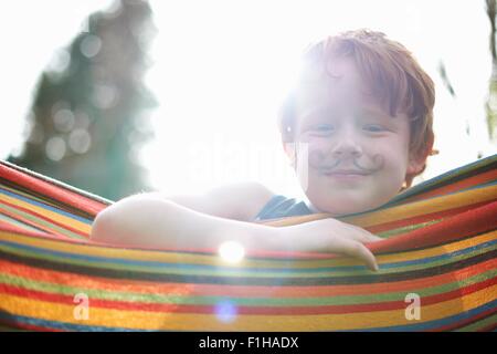 Ritratto di giovane ragazzo con disegnato su baffi Foto Stock