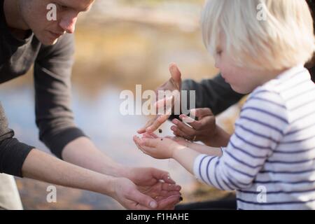 Ragazzo cattura goccioline di acqua nelle mani a tazza Foto Stock